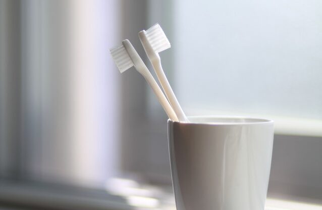 two toothbrushes in a white cup. Executive dysfunction in adults can sometimes look like not being able to do simple things like brushing your teeth, even when you know how important it is.